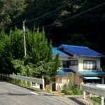 道路から見たアイカドールかもの犬舎外観（広島県福山市加茂町北山）。青い屋根の建物